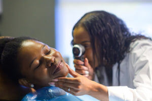 mohs surgeon using a dermatoscope to examine her skin