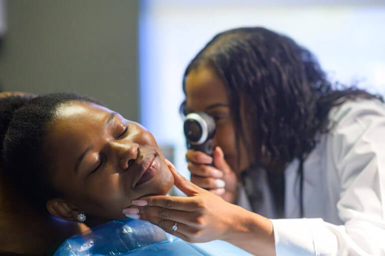 mohs surgeon using a dermatoscope to examine her skin