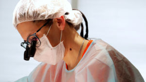 A female Mohs surgeon performing Mohs surgery for squamous cell carcinoma.